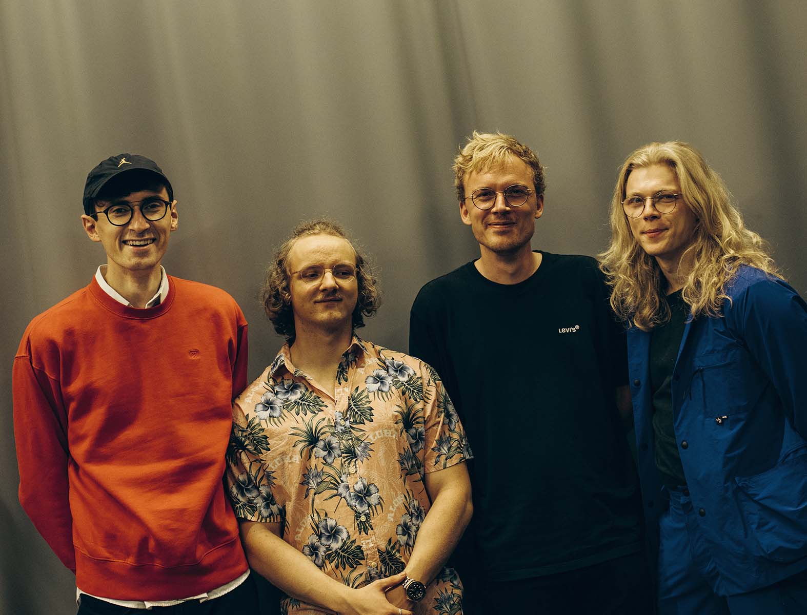 four young men smile into the camera
