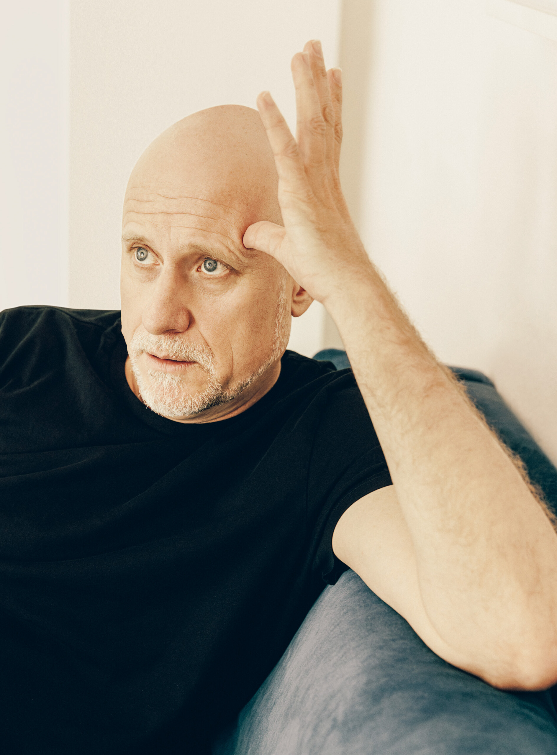 Trevor Paglen sitting on a couch, he seems deep in thought